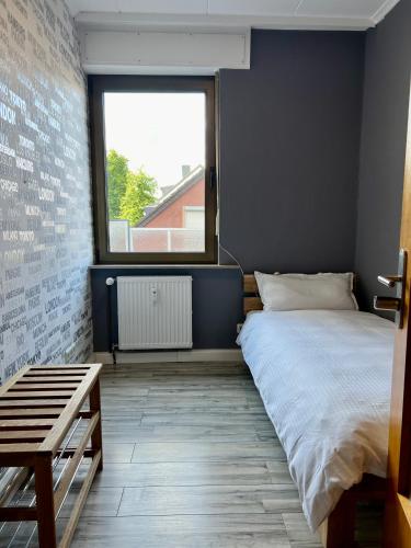 a bedroom with a large bed and a window at Bequemes Zimmer in moderner Unterkunft My Pension Duisburg in Duisburg