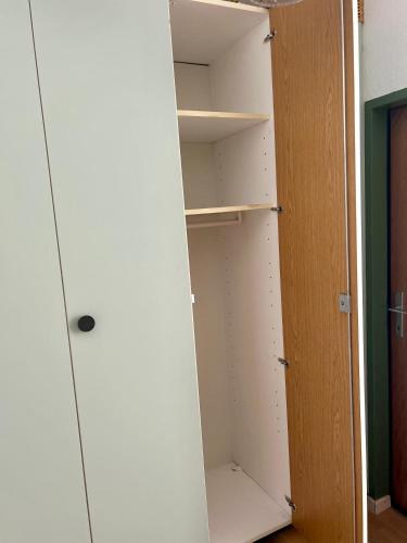 a closet with white shelves and a wooden door at M3-Alpendomizil in Mühlbach am Hochkönig