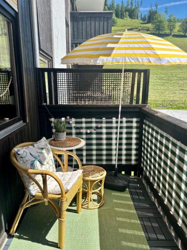 a porch with a table and an umbrella at M3-Alpendomizil in Mühlbach am Hochkönig