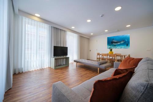 a living room with a couch and a television at Azimute 1 - T2 Moderno Centro Histórico Angra in Angra do Heroísmo