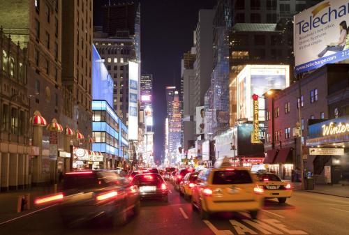 a busy city street at night with cars at The Michelangelo Hotel in New York