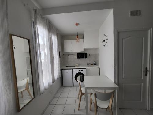 une cuisine avec une table et un chien assis sur une chaise dans l'établissement Appartement T2 spacieux de 30m2, idéal proche Paris, à Issy-les-Moulineaux