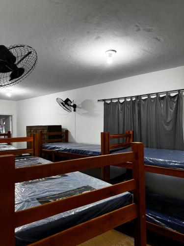 a room with four bunk beds and a curtain at Hostel Del Sol in Cabo Frio