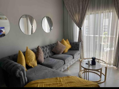 a living room with a couch and two mirrors at Dubai 8 in Midrand