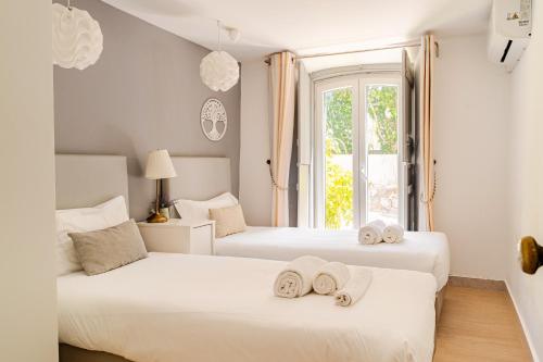 two beds in a room with towels on them at Lisbon Garden Stays, Apt close to Tram 28, Views & São Jorge Castle in Lisbon