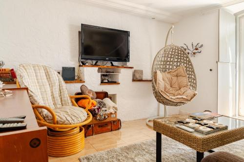 a living room with two chairs and a flat screen tv at Lisbon Garden Stays, Apt close to Tram 28, Views & São Jorge Castle in Lisbon