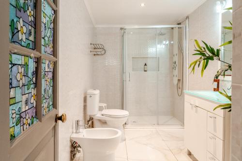 a bathroom with a toilet and a shower and a sink at Lisbon Garden Stays, Apt close to Tram 28, Views & São Jorge Castle in Lisbon