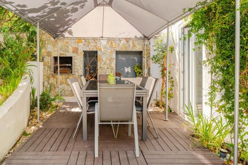 a patio with a table and chairs in a greenhouse at Lisbon Garden Stays, Apt close to Tram 28, Views & São Jorge Castle in Lisbon