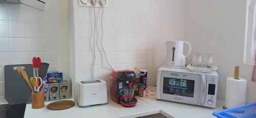 a kitchen counter with a coffee maker and a microwave at Bel appartement proche marché in Perpignan