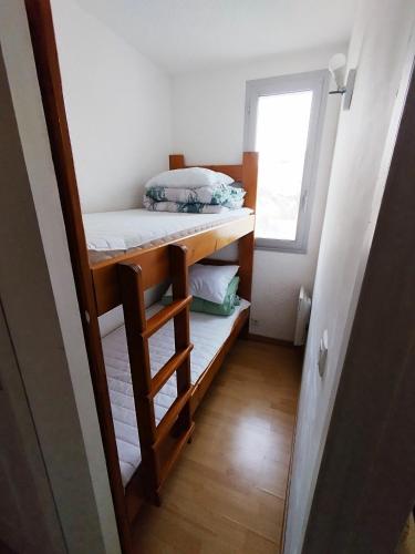 Cette petite chambre comprend des lits superposés et une fenêtre. dans l'établissement Appartement plein centre sauze, à Enchastrayes