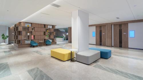 a lobby with chairs and tables in a building at Holiday Inn Express Qingdao Shibei by IHG in Qingdao