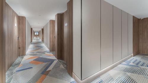 a corridor with wooden walls and a hallway with colorful tiles at Holiday Inn Express Qingdao Shibei by IHG in Qingdao