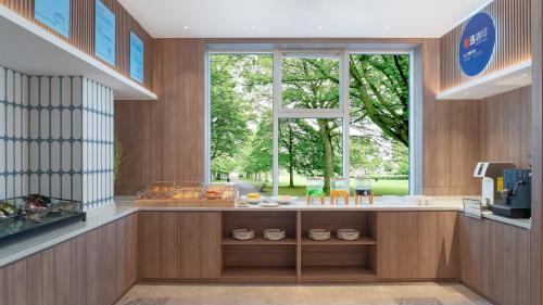 a kitchen with a counter with a window at Holiday Inn Express Qingdao Shibei by IHG in Qingdao