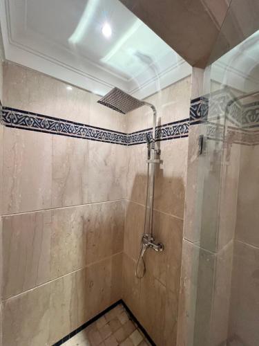 a bathroom with a shower with a shower head at Appartement de H standing in Bouznika