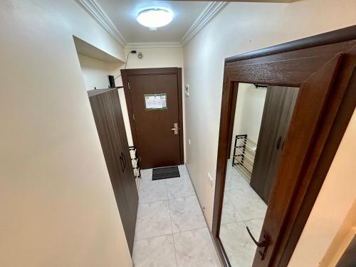 an empty hallway with two doors and a tile floor at Real Beach Tower in Batumi