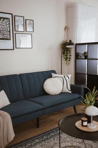 a living room with a blue couch and a table at Pablo Apartment in Cesis in Cēsis