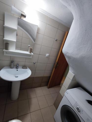 a bathroom with a sink and a washing machine at Seaside house in Sozopoli