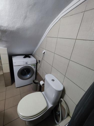 a bathroom with a toilet and a washing machine at Seaside house in Sozopoli