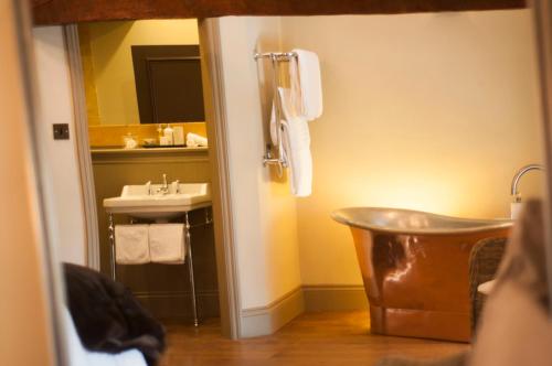 a bathroom with a tub next to a sink at The Priory in Middleham