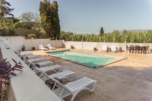 a swimming pool with lounge chairs and a table and a table and chairsktop at Petros Giatras - Rooms in Zakynthos Town