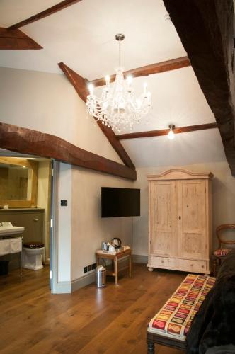 a living room with a chandelier and a tv at The Priory in Middleham