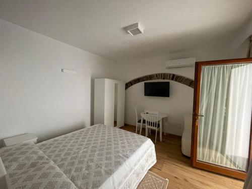a bedroom with a bed and a table and a window at Sa Troppa de sos chentu in Dorgali