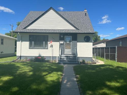 a house with a flag in the front yard at Spotless 4 Bedrooms 4 Beds Sleep 8 in Winnipeg in Winnipeg