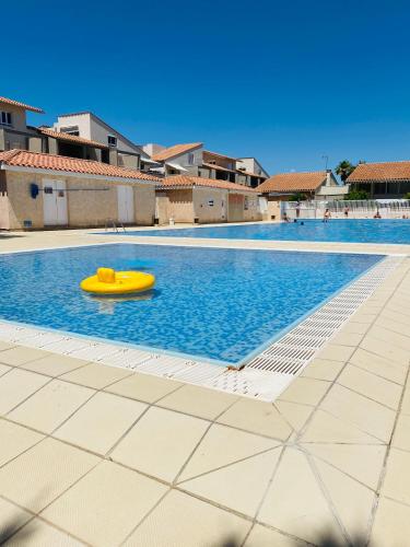 un radeau jaune au milieu d'une piscine dans l'établissement Bel appartement dans résidence de standing avec piscine et tennis, à Saint-Cyprien