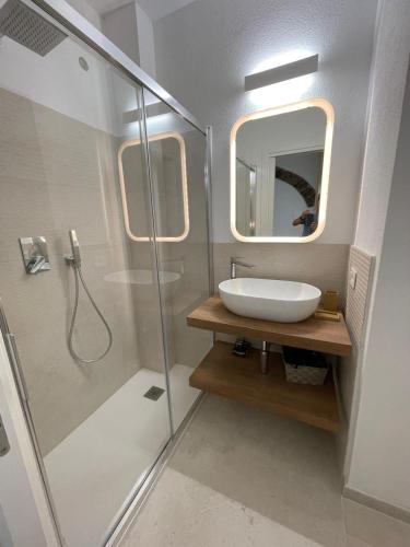 a bathroom with a sink and a shower with a mirror at Sa Troppa de sos chentu in Dorgali