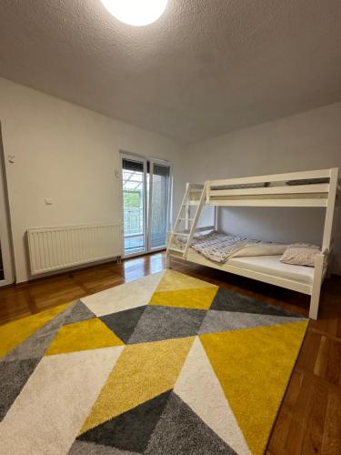 a bedroom with a bunk bed and a rug at Vila Kulo in Svrake
