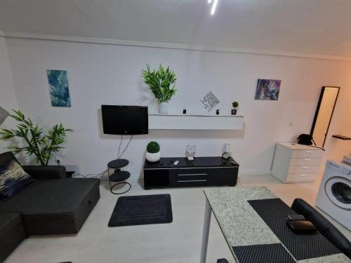 a living room with a couch and a flat screen tv at Alexa Studio with views in Ciudad Quesada