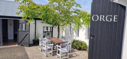 a wooden table and chairs next to a building at The Forge Cottage 1 in Wexford