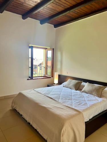 a bedroom with a large white bed with a window at Borgo del 1700- Le Scuderie- trilocale in Travedona
