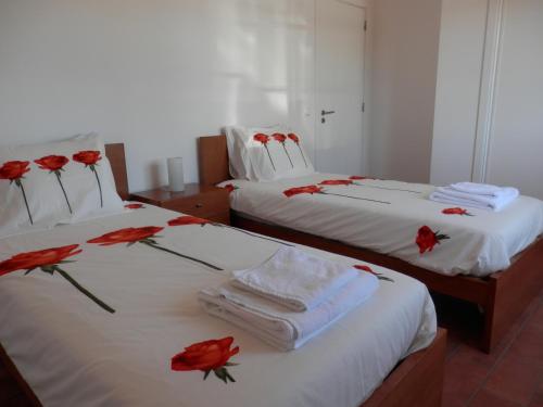 two beds with red roses on top of them at Monte da Ameira in Roncão