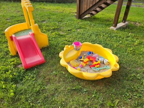 a childs play set in a sandbox in the grass at Apartament Zielono Mi, Pilchowice in Wleń