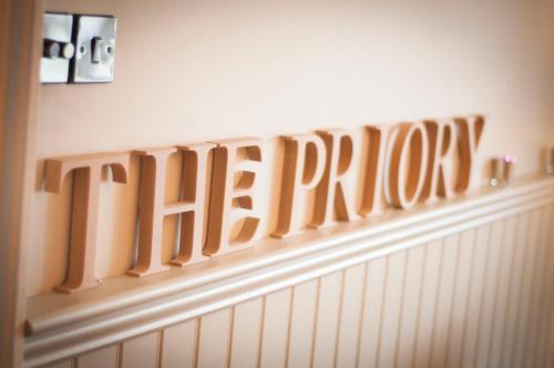 a wooden sign that says the play on a wall at The Priory in Middleham