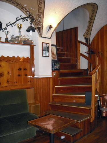 a room with a spiral staircase with a green couch at Hotel Gufo in Bormio