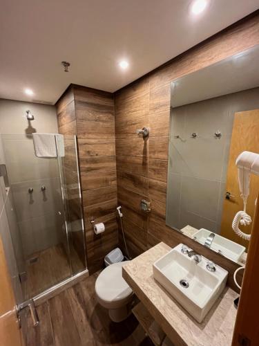 a bathroom with a toilet and a shower and a sink at Atlantis Copacabana Hotel in Rio de Janeiro