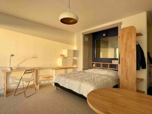 une chambre avec un lit, un bureau et une table dans l'établissement Cocon zen, face mer, plein ciel, à Le Touquet-Paris-Plage