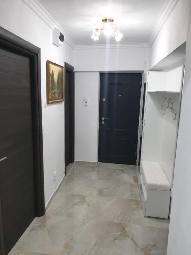 a hallway with a black door and a tile floor at Penthouse Giovanni in Orşova