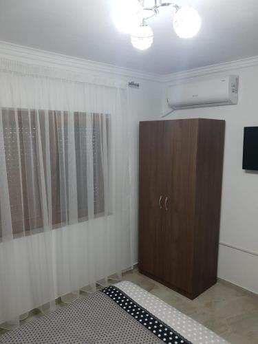 a room with a wooden cabinet and a television at Penthouse Giovanni in Orşova