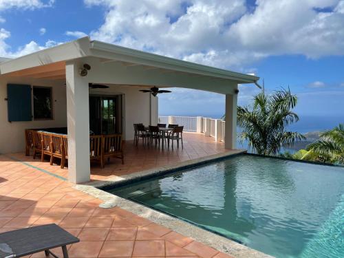 a house with a swimming pool and a patio at Private Oasis with Incredible Views in St Thomas
