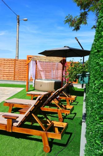 a row of wooden benches with an umbrella at Villa Crystal in Bihać