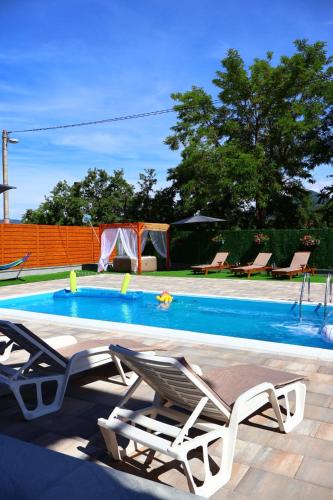 a swimming pool with two lounge chairs next to it at Villa Crystal in Bihać