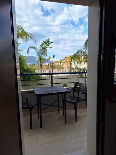 a table and chairs on a balcony with a view at Vacanze Pushime Albania in Radhimë