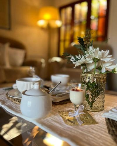 a table with white dishes and a vase with flowers at Hotel Casablanca Melo in Melo