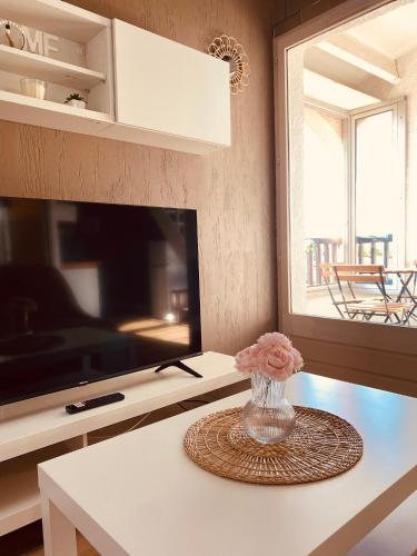 un vase de fleurs sur une table dans une cuisine dans l'établissement Appartement mezzanine au Port de Saint-Cyprien, à Saint-Cyprien