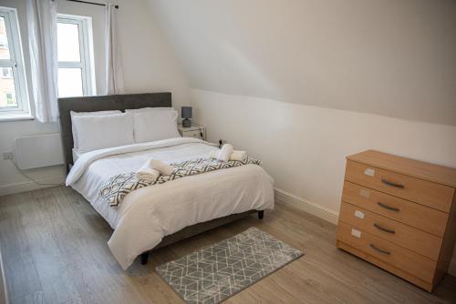 a bedroom with a large bed and a dresser at Luxury 2 bedroom apartment in Bedford in Bedford