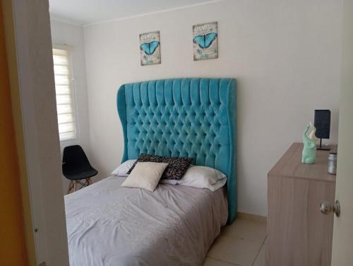 Bett mit blauem Kopfteil in einem Schlafzimmer in der Unterkunft Departamento con alberca in Tecolote