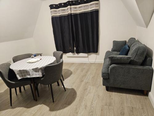 a living room with a table and chairs and a couch at Luxury 2 bedroom apartment in Bedford in Bedford